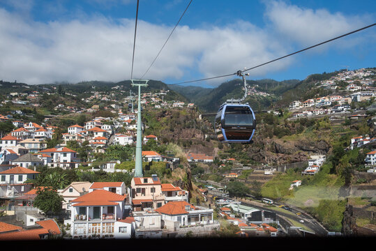 Funchal Cable Car travels above houses in Madeira with mountains in the background