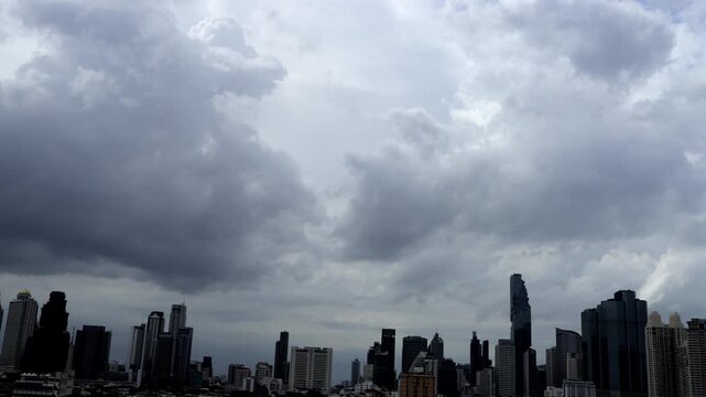 Fast-moving storm clouds gather over the Bangkok skyline, signaling an approaching downpour.