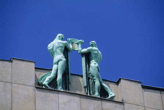 Sculpture on building roof facing crown dome of Koruna Palace in Prague, Czech Republic