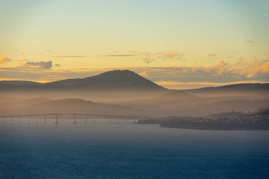 Misty sunrise over the Derwent River and Tasman Bridge in Hobart, Tasmania, with ships in port