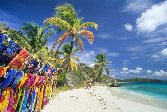 Pareo stand on Jamesby islet beach in Tobago Cays with colorful textiles and blue sky at Saint Vincent and the Grenadines