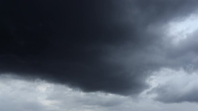 Dark storm clouds merge rapidly as severe weather develops overhead.