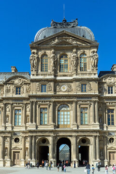 Bright spring day at the courtyard of the Louvre museum with visitors enjoying the view in Paris, France