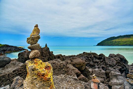 Stone stacks on rocks near the beach create a focal point against the ocean at Hamdeok Beach in Jeju Island South Korea