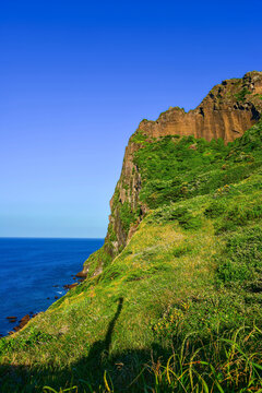 Climb the slopes of Seongsan Ilchulbong to reach the volcanic crater on Jeju Island during bright daylight hours