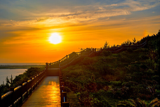 Sunset view along the pathway at Songaksan trail in Jeju Island showcases a beautiful sky and landscape