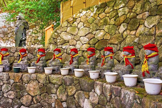 Stone sculptures of child monks with wool hats and scarves at Nanzoin Temple in autumn season in Fukuoka Kyushu Japan