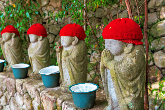 Stone sculptures of child monks dressed in red wool hats at Nanzoin Temple in autumn season, Fukuoka, Kyushu, Japan
