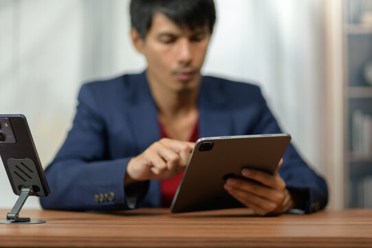 Young professional man using tablet computer in modern office setting