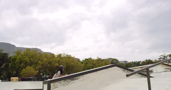 Cool young woman wearing rollerblades and doing tricks while riding at a skate park. A skilled skater in action while having fun outdoors. People practicing rollerblading techniques for recreation