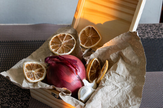 Rustic Culinary Still Life with Red Onion, Garlic, and Dried Lemon Slices in a Wooden Box