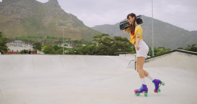 Female roller skater with a boombox dancing in a skate park outside, spinning and moonwalking backwards having fun. A cool urban skater full of energy listening to music on a radio on her shoulder
