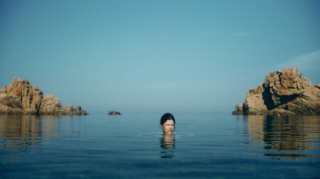 portrait of woman in the sea at sunrise in Sardinia