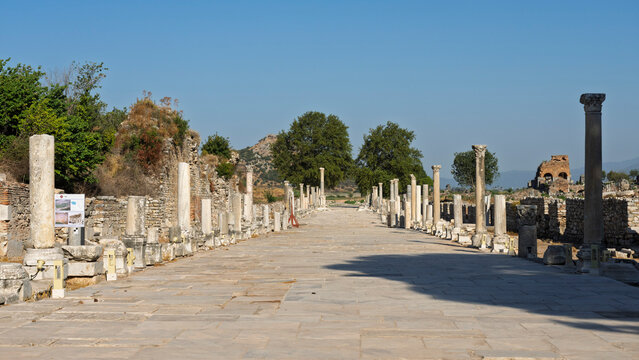 Exploring ancient ruins of Ephesus with marble columns under clear blue sky in Turkey