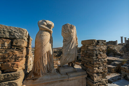 Exploring the House of Cleopatra in Delos with ancient sculptures under a clear sky