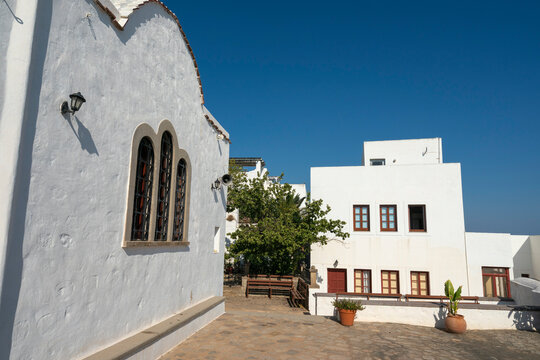 Church of Panagia i Diasozousa stands near white buildings under blue sky in Chora, Patmos, Greece