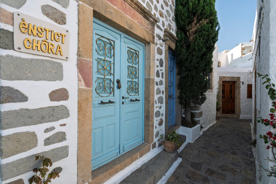 Quiet street in Chora with blue doors and stone walls in Patmos, Greece, showcasing local architecture and charm in a narrow pathway
