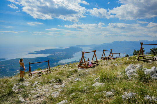 Tourists Relaxing at Mountain Viewpoint Above Kotor Bay Montenegro