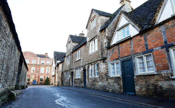 Traditional architecture lines the street in the town of Lacock, showcasing late medieval and early modern styles in Wiltshire, England