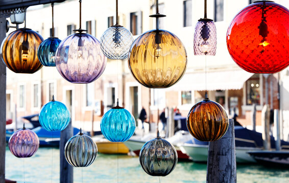 Colorful glass ornaments hanging above a canal in Murano showcase the island's famous glass making tradition in Italy
