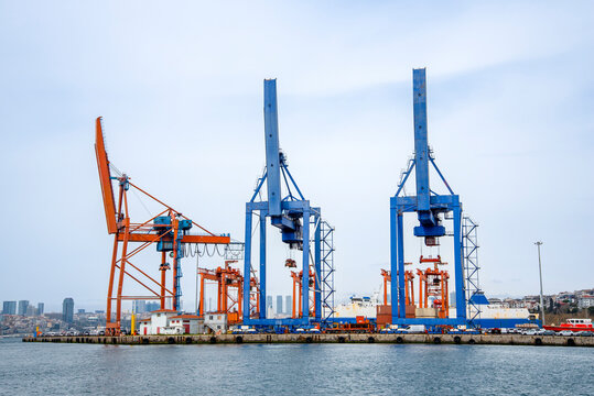 Cranes and cargo at a busy shipping port in Istanbul during a cloudy day