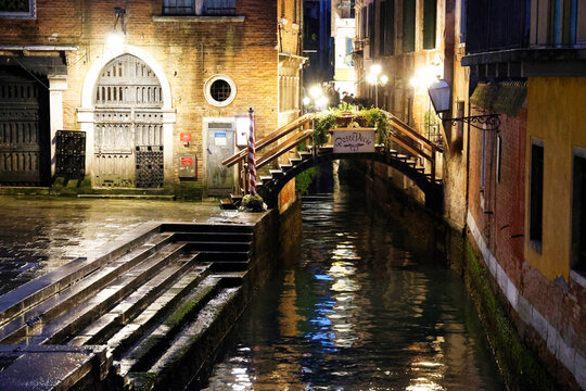 Street scenes show canals and bridges in Venice at night with lights reflecting on the water in Italy