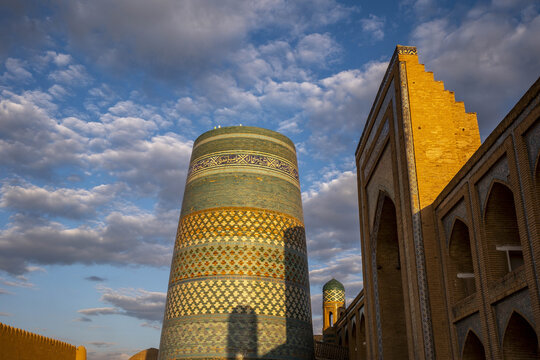 Kalta minar minaret and madrasa in Itchan Kala with historic architecture in Khiva, Uzbekistan during sunset