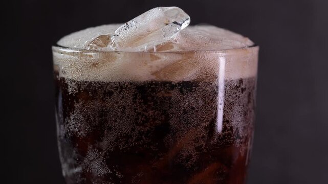 Cola soft drink with ice cubes, soda fizzy drink in Cold glass close-up