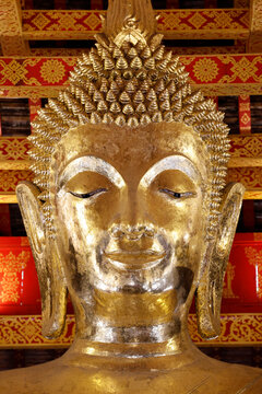 Golden statue of Buddha Shakyamuni at Wat Visounnarath in Luang Prabang, Laos, displays intricate details and craftsmanship