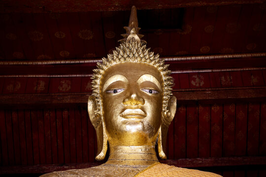 Giant golden Buddha statue at Wat May Souvannapoumaram in Luang Prabang, Laos offers a view of cultural heritage