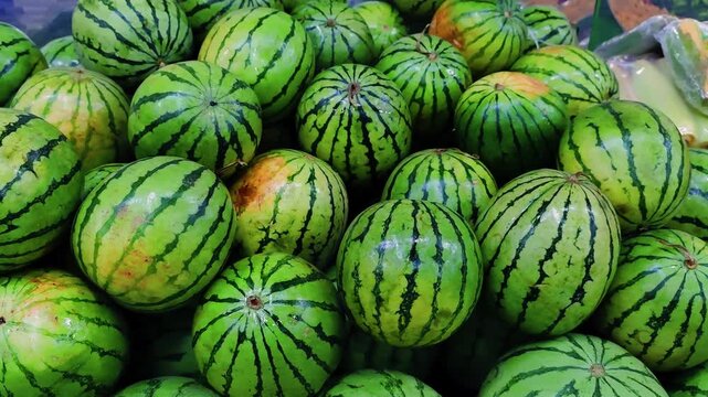 Mini Watermelons (Citrullus lanatus) Stacked for Sale at a Fresh Produce Market, 4K 60fps
