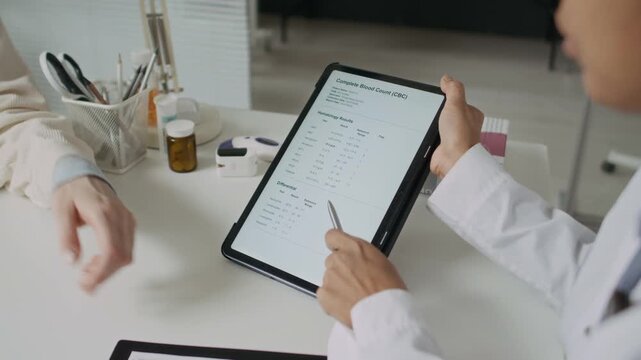 Unrecognizable female doctor explaining complete blood count test results on tablet to female patient. Ideal for medical clinic marketing and digital health app promotions