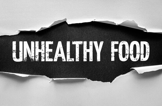 Torn paper reveals the bold grunge words UNHEALTHY FOOD underneath, symbolizing poor diet, processed meals, and nutrition concerns breaking through a surface with distressed typography
