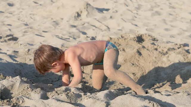 Happy Child Playing in the Sand on a Beautiful Summer Beach