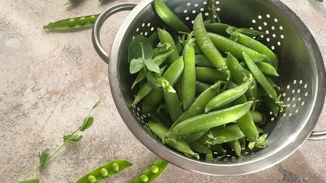 Fresh green peas rotating in a colander