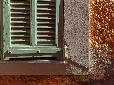 D&eacute;tail d'une fen&ecirc;tre proven&ccedil;ale avec un volet vert un jour ensoleill&eacute;