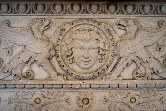 Carved Stone Face Relief with Griffins