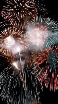 Colorful fireworks exploding in the night sky on a dark background, vertical video featuring vibrant celebrations for New Year, festivals and special events
