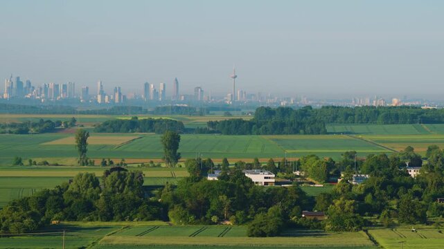 Aerial view of a field at sunrise. A landscape from a drone perspective, with a view of the metropolis of Frankfurt am Main. An agricultural landscape from the air.