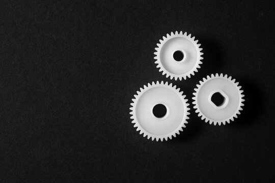 White Plastic Gears on Black Background with Copy Space