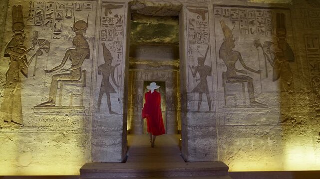 Woman in a red dress exploring the temple in Abu Simbel, Egypt.