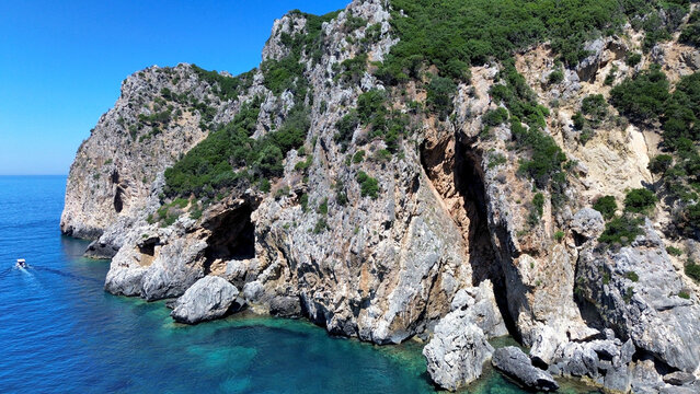 Aerial view of the wild Gyali beach in Corfu, Greece, with dramatic high cliffs and crystal clear turquoise sea.
