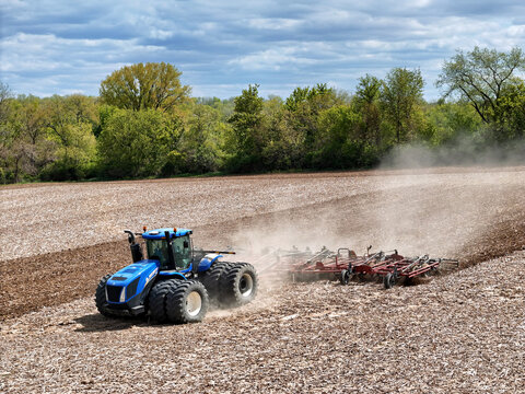 Caledonia, Illinois May 6, 2026 - New Holland T9505 Tractor pulling a Case IH Tiger-Mate 200 field cultivator for Spring Fieldwork