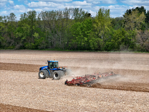 Caledonia, Illinois May 6, 2026 - New Holland T9505 Tractor pulling a Case IH Tiger-Mate 200 field cultivator for Spring Fieldwork