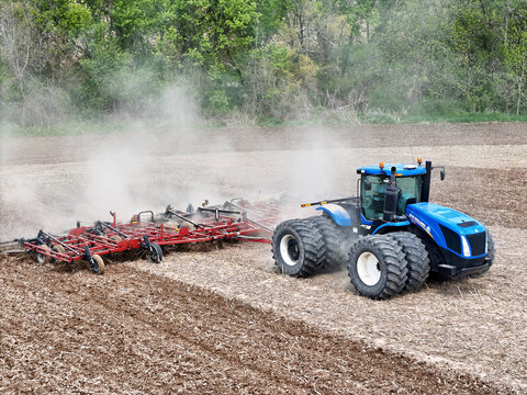 Caledonia, Illinois May 6, 2026 - New Holland T9505 Tractor pulling a Case IH Tiger-Mate 200 field cultivator for Spring Fieldwork