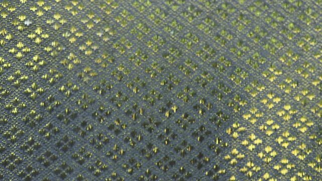 Curtains featuring an intricate diamond pattern known as lai khao lam tad combine geometric shapes with shimmering gold threads.