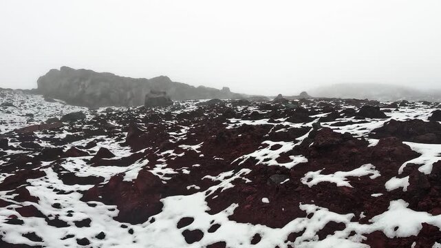 Snowy Andean Mountain Ridge in Ecuador with Dark Volcanic Rocks, Fog, Rugged Terrain and Remote High Altitude Wilderness Landscape