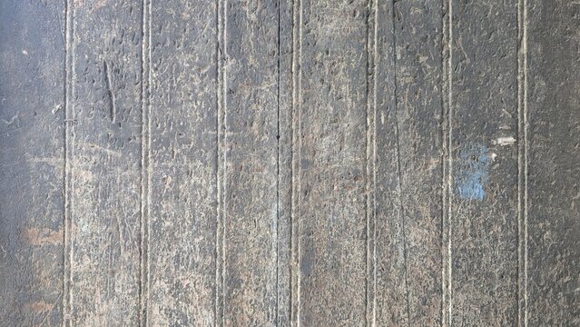 Grungy oil stained wooden surface industrial backdrop. Abstract time-worn distressed wooden boards texture. Textured abstract of damaged dark wooden panel with heavy grime and industrial oil marks.