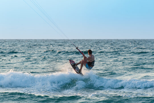 surfer jumping in the sea on a sunny day