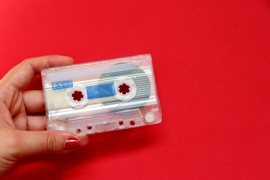 Vintage audio cassette tape on a red background. Old cassette tape with copy space. 